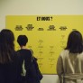 Photo d'ambiance du vernissage de l'exposition "Migrations & climat". Personnes devant un panneau avec l'inscirption : "Et vous ?"