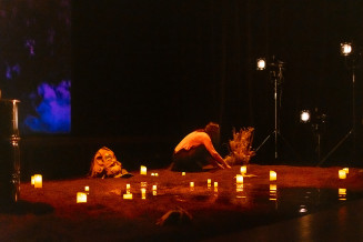 vue d'ensemble de la scène de la pièce Nos corps empoisonnés, bougies dispersées sur le sol