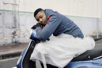 Photographie d'un jeune homme marseillais assis sur un scooter en tutu 