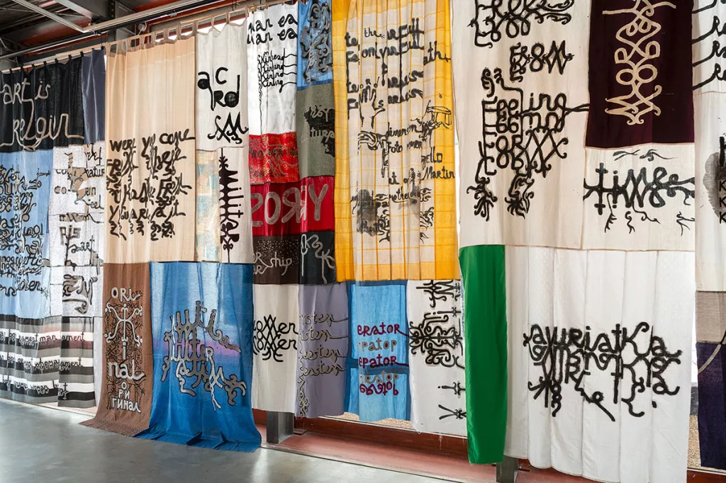 Exposition à la Fondation du Doute (2026) Patchwork de toiles avec des mots écrits 