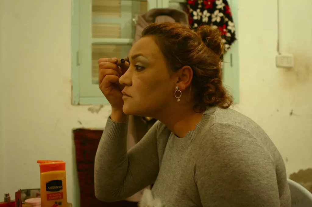 Femme qui se maquille devant un miroir