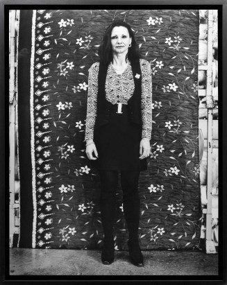 Portrait d'une femme debout devant un fond en tissu