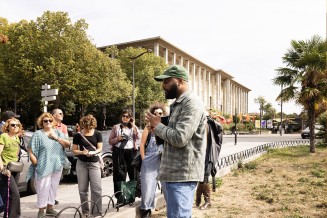 Public assistant à une visite guidée devant le Palais
