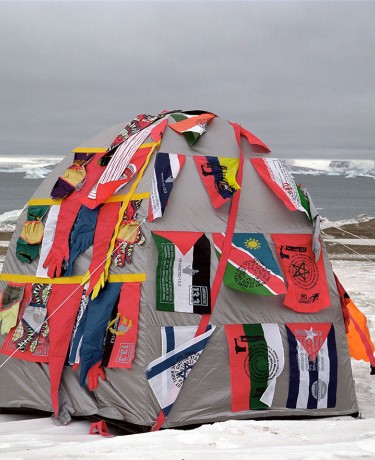 Photo d'une tente recouverte de drapeaux