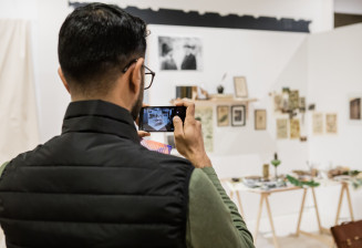 jeune prenant une photo d'une exposition